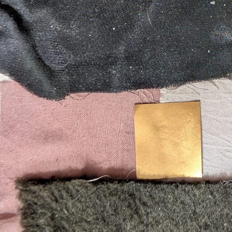 Verschillende texturen van stof in diverse kleuren, met een gouden vierkantje.